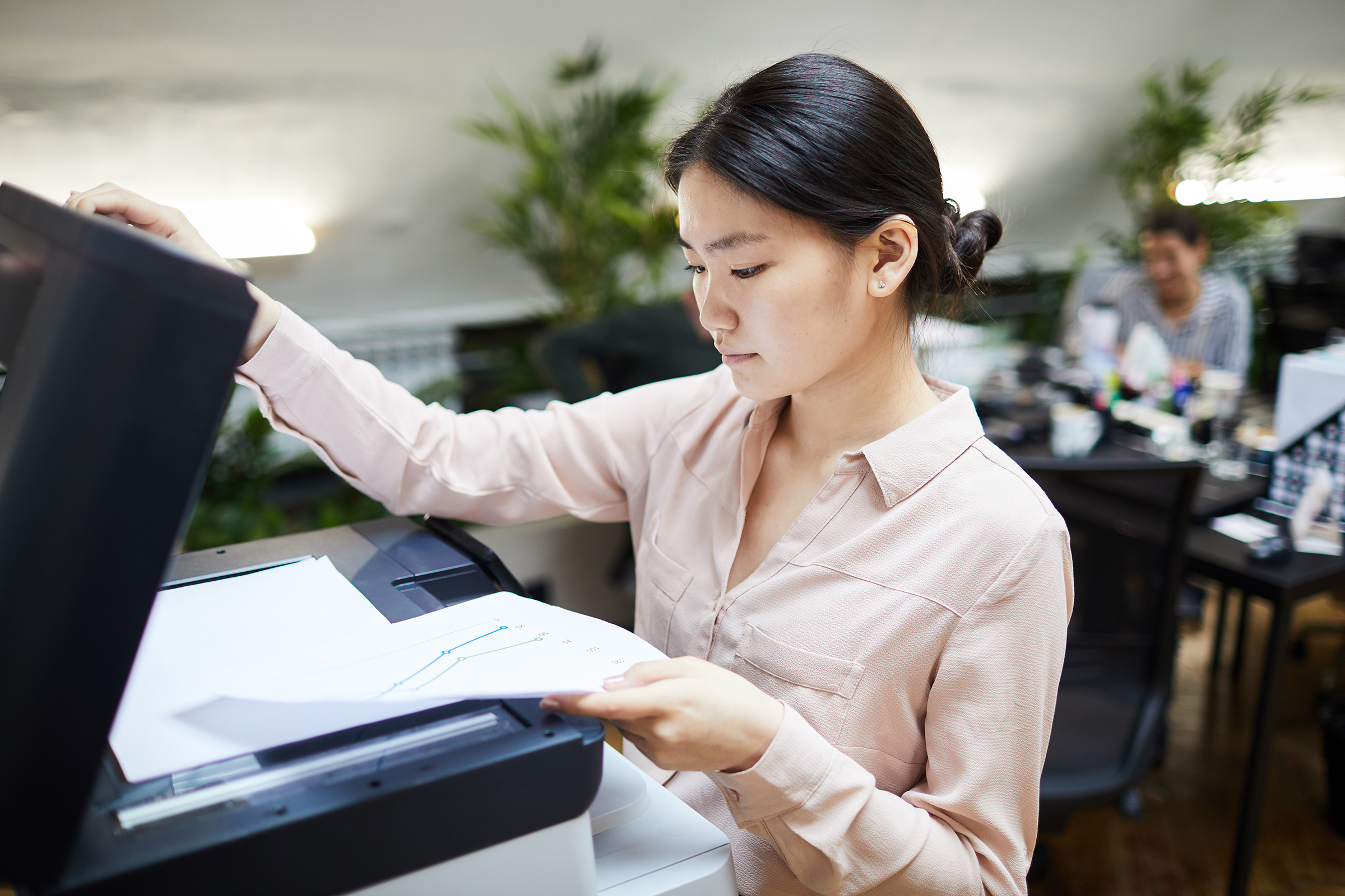 asian businesswoman printing documents in office