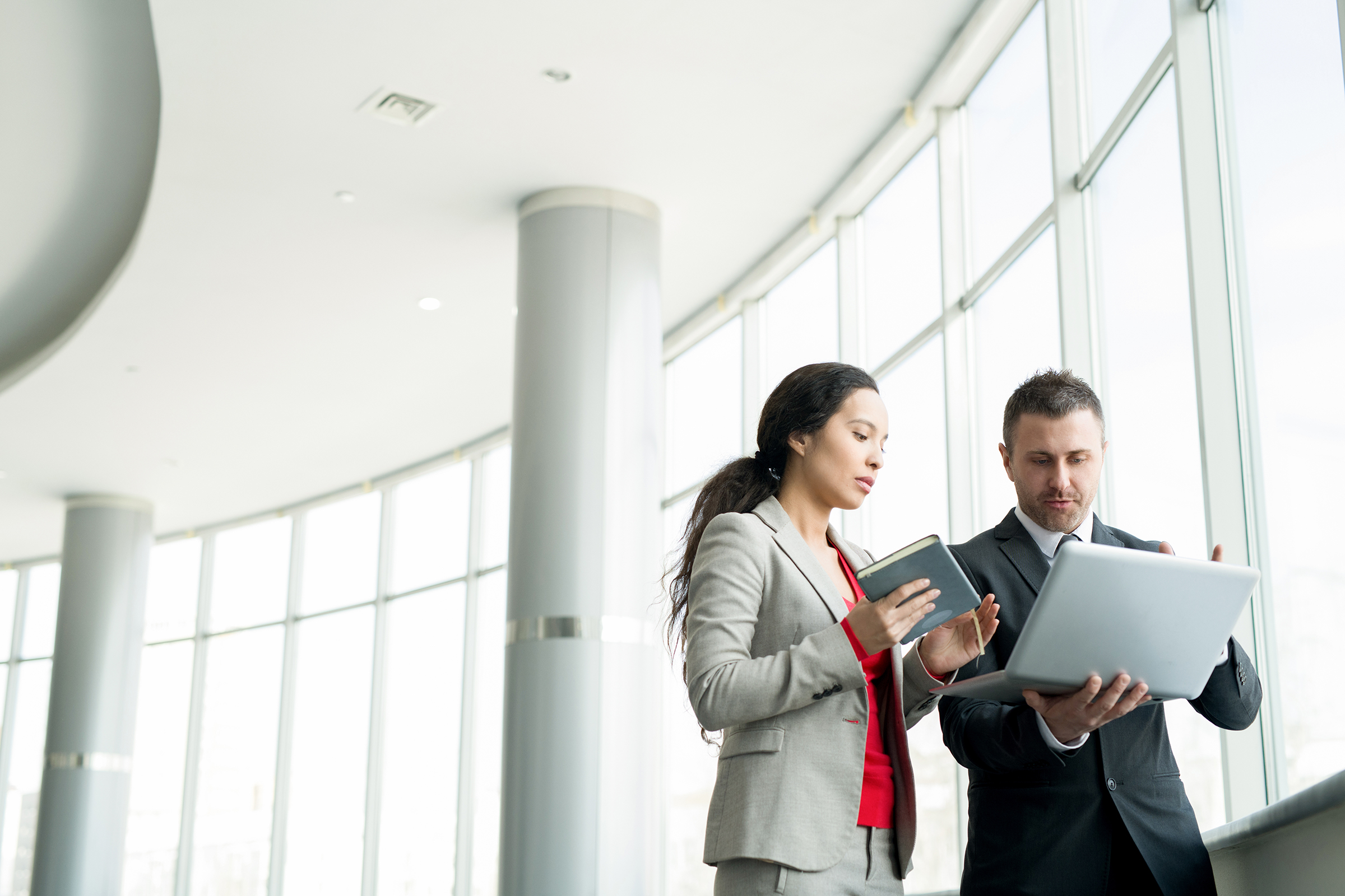 businesswoman talking to colleague by window