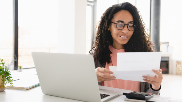 Happy African female checking her billing statement