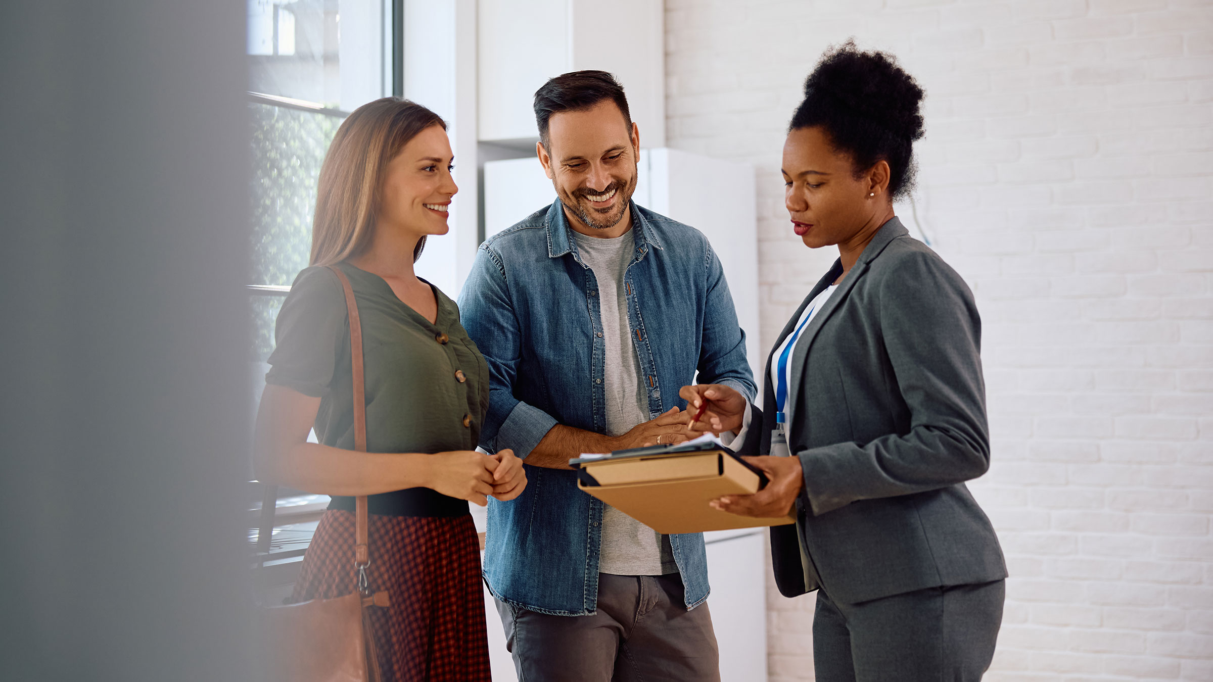 Happy couple at home going over paper work with agent