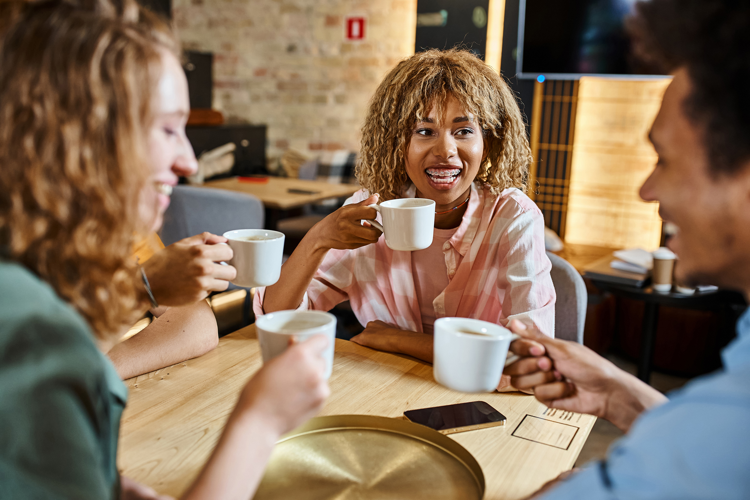 happy multiethnic students drinking coffee and talking