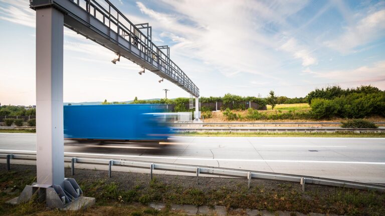 Truck on highway passing under toll