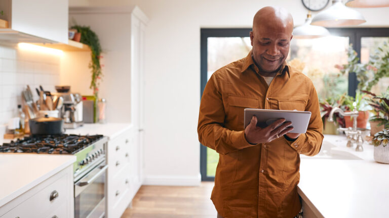 Man using digital tablet in kitchen